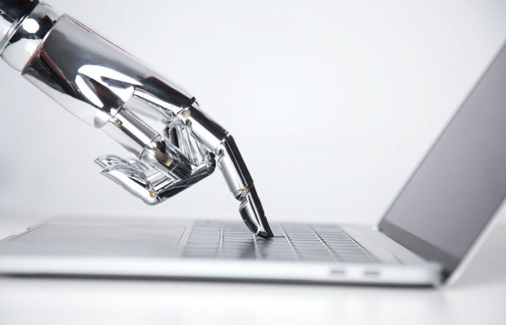 Blog banner showing a robotic hand pressing a laptop keyboard to illustrate the title "机器翻译vs. human Translation: Will Artificial Intelligence Replace the World’s Second Oldest Profession?"